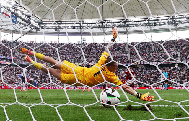 Morten Hjulmand dari Denmark mencetak gol pertama mereka melewati Jordan Pickford dari Inggris pada laga Denmark melawan Inggris saat Piala Eropa 2024 di Deutsche Bank Park, Jerman, Kamis (20/6/2024). Foto: Kai Pfaffenbach/REUTERS