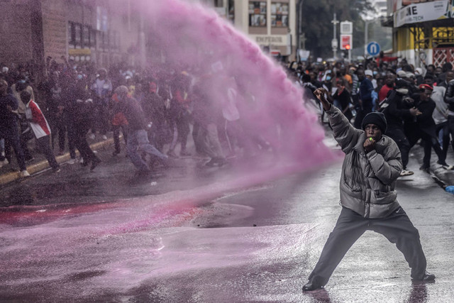 Seorang pengunjuk rasa bereaksi ketika petugas Polisi Kenya menyemprotkan air untuk membubarkan massa selama demonstrasi menentang kenaikan pajak di pusat kota Nairoibi, Kenya, Kamis (20/6/2024). Foto: SIMON MAINA/AFP