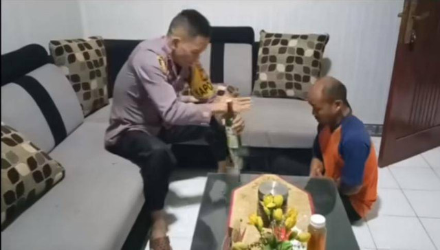 Kapolsek Banjarwangi, Iptu Amirudin Latif, saat memecahkan sebuah botol miras utuh dengan satu hentakan tangan. (Foto: Istimewa)