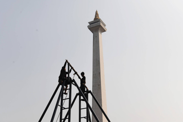 Pekerja merangkai wahana hiburan rakyat di area Pasar Malam di Silang Monas, Jakarta, Jumat (21/06/2024). Foto: Akbar Nugroho Gumay/ANTARA FOTO