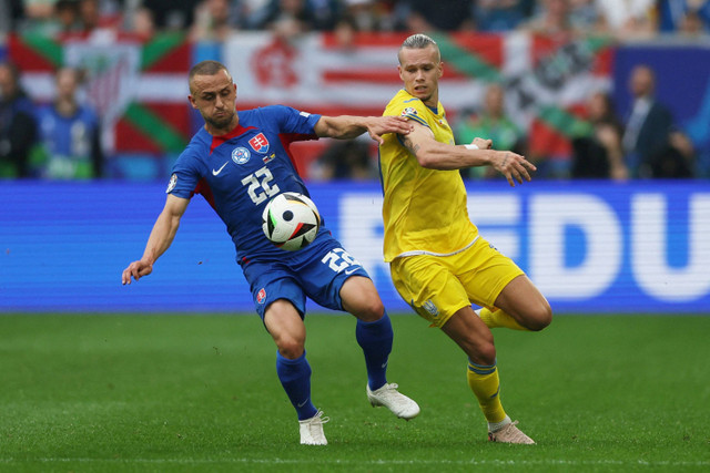 Pemain Slovakia Stanislav Lobotka beraksi bersama pemain Ukraina Mykhailo Mudryk di Dusseldorf Arena, Dusseldorf, Jerman, Jumat (21/6/2024). Foto: Thilo Schmuelgen/Reuters