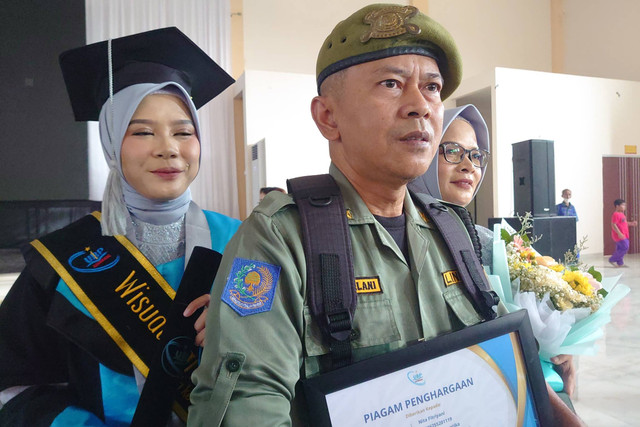 Hansip yang kuliahkan anak hingga lulus cumlaude di UBP Karawang. Foto: Dok. Istimewa