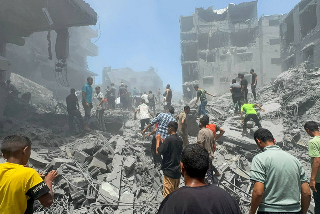 Warga Palestina mencari korban di lokasi serangan Israel terhadap rumah-rumah di kamp pengungsi Al Shati di Kota Gaza, Sabtu (22/6/2024). Foto: Ayman Al Hassi/REUTERS