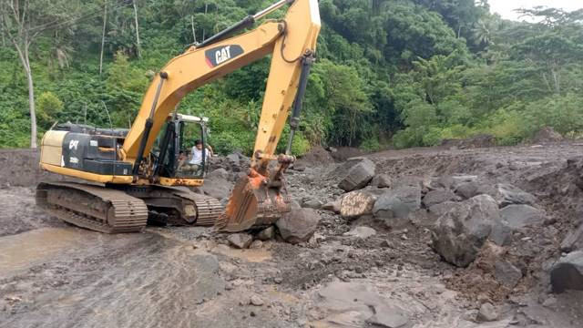 Alat berat yang digunakan Pemerintah Kabupaten Sitaro untuk membersihkan jalan yang tertutup material yang berasal dari banjir lahar dingin Gunung Karangetang. (foto: pemkab sitaro)