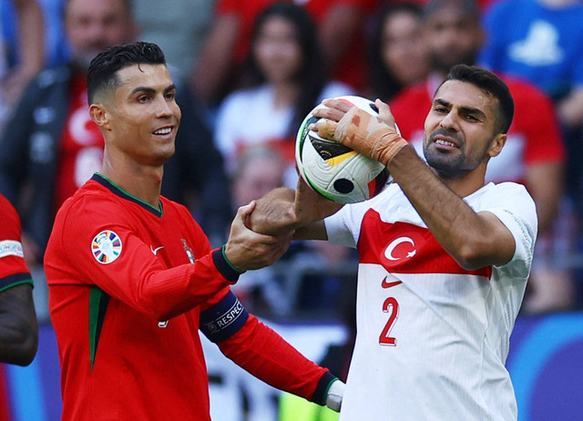 Ekspresi Cristiano Ronaldo dan Zeki Celik saat Turki vs Portugal dalam matchday kedua Grup F Piala Eropa 2024 di Signal Iduna Park, Jerman, pada Sabtu (22/6) malam WIB. Foto: REUTERS/Kacper Pempel