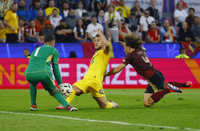 Koen Casteels dan Wouf Faes coba setop Denis Dragus saat Belgia vs Rumania dalam matchday kedua Grup E Piala Eropa 2024 di Cologne Stadium, Jerman, pada Minggu (23/6) dini hari WIB. Foto: REUTERS/Thilo Schmuelgen