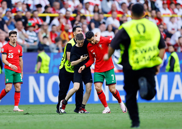 Penyusup paksa Cristiano Ronaldo selfie dengannya saat Turki vs Portugal dalam matchday kedua Grup F Piala Eropa 2024 di Signal Iduna Park, Jerman, pada Sabtu (22/6) malam WIB. Foto: REUTERS/Leon Kuegeler