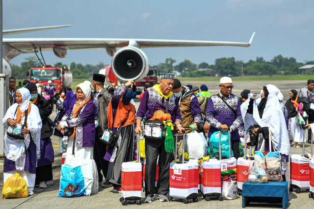 Jemaah haji kelompok terbang (kloter) pertama debarkasi Palembang menunggu kedatangan bus setibanya di Bandara Sultan Mahmud Baddarudin (SMB) II Palembang, Sumatera Selatan, Minggu (23/6/2024). Foto: Nova Wahyudi/ANTARA FOTO