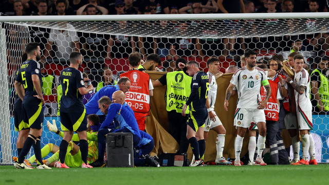 Barnabas Varga dapat perawatan usai bertabrakan dengan Angus Gunn saat Skotlandia vs Hongaria dalam laga terakhir Grup A Piala Eropa 2024 di Stuttgart Arena pada Senin (24/6) dini hari WIB. Foto: REUTERS/Lee Smith