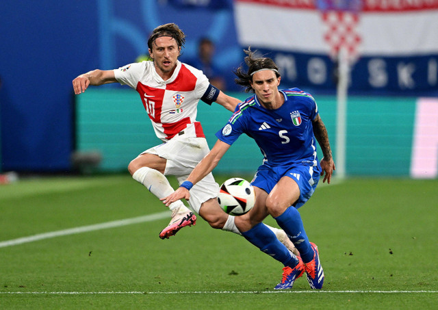 Luka Modric duel dengan Riccardo Calafiori saat Kroasia vs Italia dalam laga terakhir Grup B Piala Eropa 2024 di Leipzig Stadium, Jerman, pada Selasa (25/6) dini hari WIB. Foto: REUTERS/Angelika Warmuth