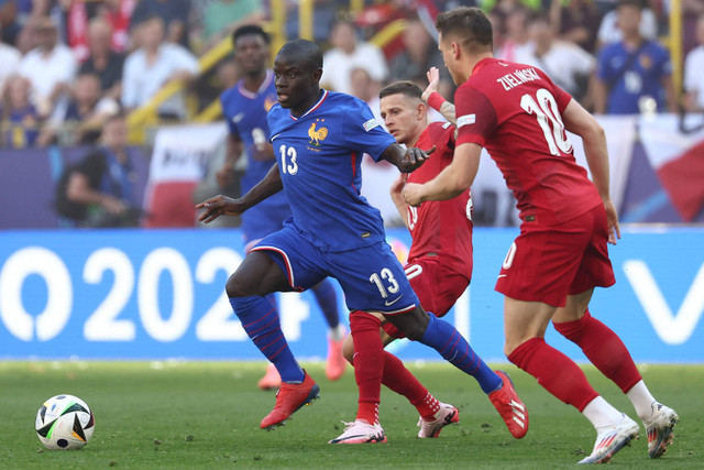 Pemain Timnas Prancis N'Golo Kante berusaha melewati pemain Timnas Polandia Sebastian Szymanski pada pertandingan Grup D Piala Eropa 2024 di Signal Iduna Park, Dortmund, Jerman, Selasa (25/6/2024). Foto: FRANCK FIFE / AFP