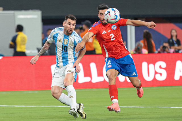 Penyerang Argentina, Lionel Messi memainkan bola melawan pemain bertahan Chile, Gabriel Suazo saat pertandingan Chile melawan Argentina pada Copa America 2024 di MetLife Stadium, Rabu (26/6/2024). Foto: Vincent Carchietta-USA TODAY Sports via REUTERS 