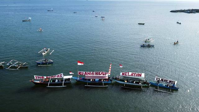 Spanduk penolakan reklamasi teluk Manado yang dipasang di kapal milik nelayan di Pantai Karangria.