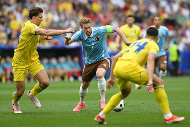 Pemain Timnas Ukraina Illia Zabarnyi berebut bola dengan pemain Timnas Belgia Kevin de Bruyne pada pertandingan Grup E Piala Eropa 2024 di Stuttgart Arena, Stuttgart, Jerman, Rabu (26/6/2024). Foto: THOMAS KIENZLE / AFP