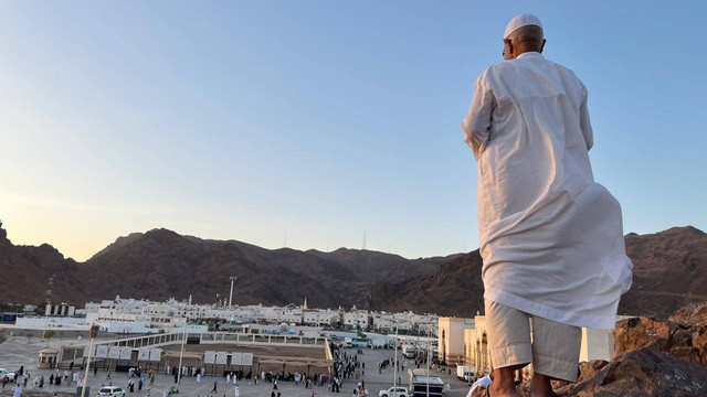 Peziarah berdoa sambil memandang Jabal Uhud dari atas Bukit Rumat.  Foto: Salmah Muslimah/kumparan