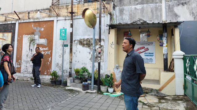 Warga RW 04 Kelurahan Cokrodiningratan menunjukkan kampungnya berada di belakang SMPN 6 Yogya. Foto: Arfiansyah Panji Purnandaru/kumparan