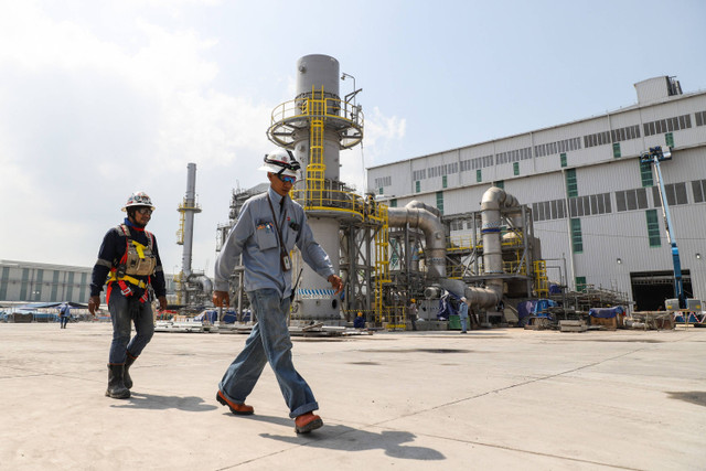 Pekerja melintas di dekat proyek Smelter Freeport di Kawasan Ekonomi Khusus Java Integrated and Industrial Port Estate (KEK JIIPE), Gresik, Jawa Timur, Sabtu (25/5/2024). Foto: Rizal Hanafi/ANTARA FOTO