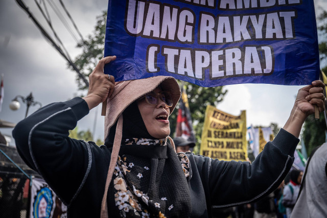 Seorang buruh mengangkat poster aksi saat unjuk rasa menolak program Tapera di depan Kantor Kementerian Keuangan, Jakarta, Kamis (27/6/2024). Foto: ANTARA FOTO/Bayu Pratama S