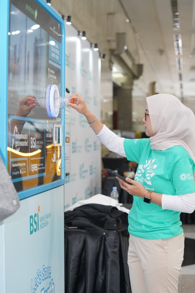 Pengunjung memasukkan botol di mesin RVM (Reverse Vending Machine) mesin pengolah botol plastik pada gelaran BSI International Expo 2024. Foto: Dok. BSI