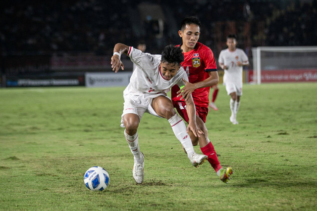 Pemain  Timnas Indonesia U-16 I Putu Panji Apriawan berebut bola dengan pemain Timnas Laos Ki Mounkanyah (kanan) pada pertandingan penyisihan grup A Piala AFF U-16 di Stadion Manahan, Solo, Jawa Tengah, Kamis (27/6/2024). Foto: Mohammad Ayudha/ANTARA FOTO