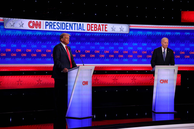 Kandidat Partai Demokrat, Presiden AS Joe Biden, dan kandidat Partai Republik, mantan Presiden AS Donald Trump, berdiri di podium mereka pada awal debat presiden di Atlanta, Georgia, AS, Kamis (27/6/2024). Foto: Brian Snyder/REUTERS