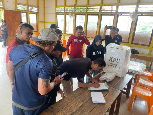 Komisioner KPU Sintang Vesius Dien membantu distribusi logistik ke Desa Nanga Tekungai, Kecamatan Serawai. Foto: Yusrizal/Hi!Pontianak