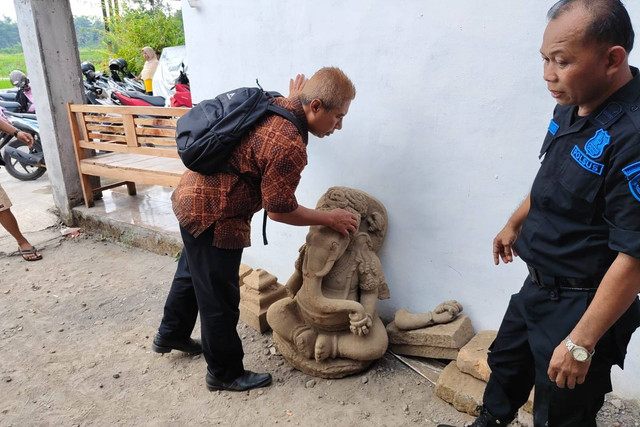 Petugas Balai Pelestarian Kebudayaan Wilayah X mengamati arca ganesha yang ditemukan di Dusun Sayidan, Kalurahan Sumberadi, Kapanewon Mlati, Kabupaten Sleman, Jumat (28/6/2024). Foto: Arfiansyah Panji Purnandaru/kumparan