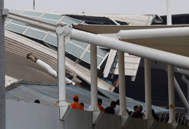 Orang-orang berdiri di depan bagian kanopi yang rusak di Terminal 1 menyusul hujan lebat di Bandara Internasional Indira Gandhi di New Delhi, India 28 Juni 2024. Foto: REUTERS/Priyanshu Singh