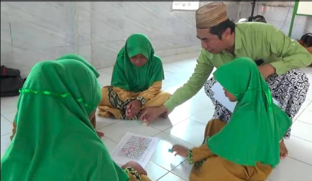 Imam Subawaihin saat mengajar menggunakan permainan ular tangga. Foto: Muhammad Zain/Hi!Pontianak