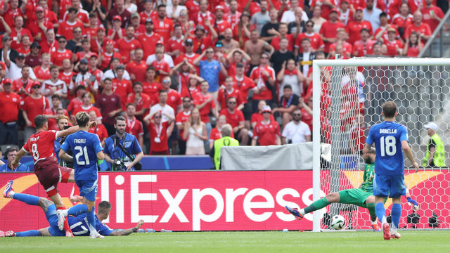 Gelandang Swiss Remo Freuler (Kiri) mencetak gol pertama timnya pada pertandingan sepak bola babak 16 besar UEFA Euro 2024 antara Swiss dan Italia di Olympiastadion Berlin di Berlin pada 29 Juni 2024. Foto: Ronny Hartmann / AFP