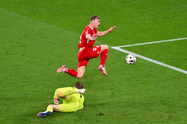 Penjaga gawang Timnas Jerman Manuel Neuer berusaha menghadang pemain Timnas Denmark Rasmus Hojlund pada pertandingan 16 besar Piala Eropa 2024 di Signal Iduna Park, Dortmund, Jerman, Minggu (30/6/2024). Foto: ALBERTO PIZZOLI / AFP