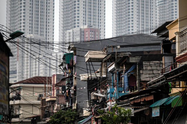 Deretan permukiman penduduk dengan latar belakang apartemen di kawasan Muara Angke, Jakarta, Senin (1/7/2024). Foto: Aprilio Akbar/ANTARA FOTO