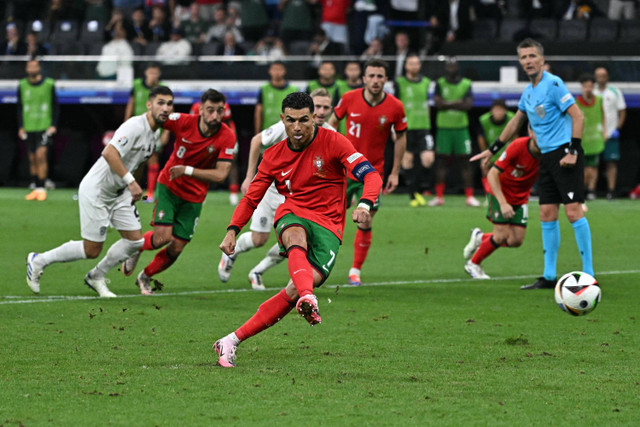 Pemain Timnas Portugal Cristiano Ronaldo menendang penalti ke gawang Timnas Slovenia pada pertandingan 16 besar Piala Eropa 2024 di Frankfurt Arena, Frankfurt, Jerman, Selasa (2/7/2024). Foto: JAVIER SORIANO / AFP