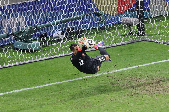 Penjaga gawang Timnas Portugal Diogo Costa menggagalkan tendangan penalti pemain Timnas Slovenia Benjamin Verbic pada pertandingan 16 besar Piala Eropa 2024 di Frankfurt Arena, Frankfurt, Jerman, Selasa (2/7/2024). Foto: Daniel ROLAND / AFP