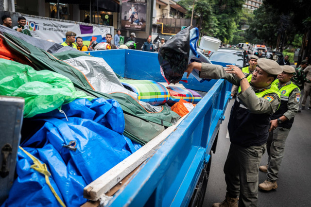 Petugas Satpol PP memuat barang dan tenda pengungsi warga negara asing (WNA) saat penertiban di depan Kantor UNCHR, kawasan Kuningan, Jakarta, Selasa (2/7/2024). Foto: Bayu Pratama S/ANTARA FOTO
