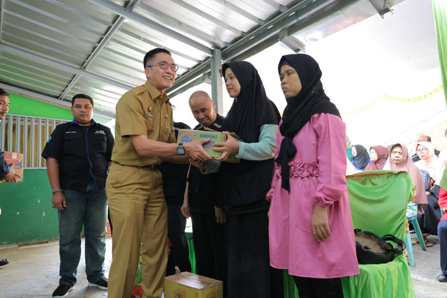 Sekda Kota Palembang, Ratu Dewa, saat menyalurkan bantuan ke penyandang disabilitas. (is)