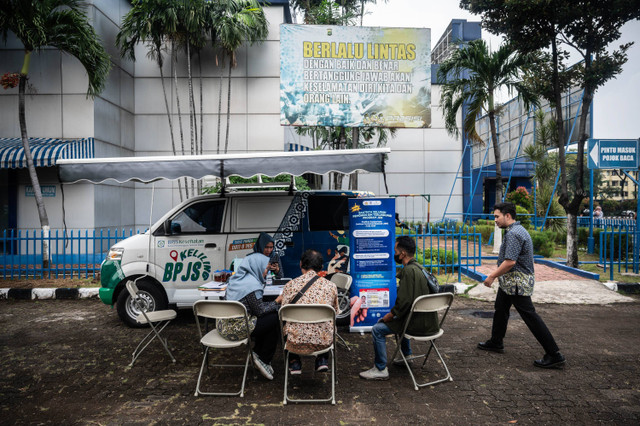 Petugas BPJS Kesehatan membantu pemohon Surat Izin Mengemudi memeriksa status aktif kepesertaan BPJS Kesehatan saat melakukan perpanjangan SIM di Satuan Penyelenggara Administrasi SIM Polda Metro Jaya, Daan Mogot, Selasa (2/7/2024). Foto: Aprilio Akbar/ANTARA FOTO