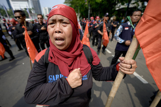 Para pekerja meneriakkan slogan-slogan saat melakukan unjuk rasa di Jakarta pada tanggal 3 Juli 2024. Foto: BAY ISMOYO / AFP