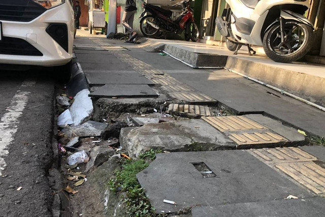 Penampakan salah satu lubang di sepanjang trotoar kawasan wisata sepatu Cibaduyut, Rabu (3/7/2024). Foto: Robby Bouceu/kumparan