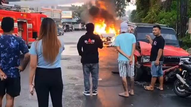 Mobil pemadam kebakaran berupaya memadamkan api yang membakar mobil Toyota Avanza yang alami kecelakaan di ruas jalan Paal II, Kota Manado, Sulawesi Utara.