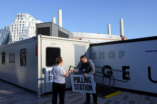 Petugas pemungutan suara mempersiapkan tempat pemungutan suara  Pemilu Inggris 2024 di samping Pembangkit Listrik Battersea, London, Inggris, Kamis (4/7/2024). Foto: Toby Melville/ REUTERS