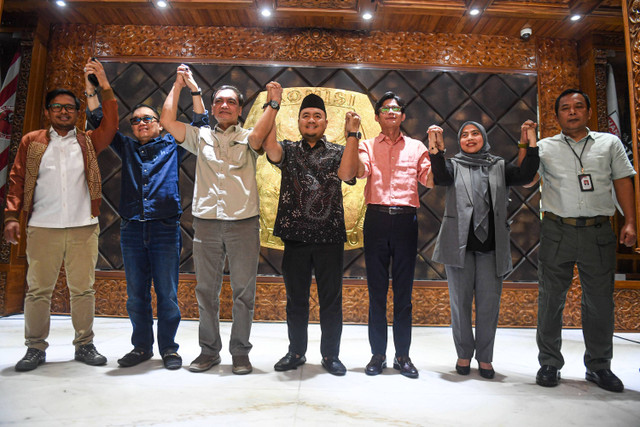 Plt Ketua KPU Mochammad Afifuddin (tengah) bersama Komisioner KPU Idham Holik, Parsadaan Harahap, Yulianto Sudrajat, Agus Mellaz, Betty Epsilon, dan Sekjen KPU Bernard Dermawan Sutrisno mengangkat tangan bersama usai konferesi pers di Kantor KPU, Kamis (4/7). Foto: Muhammad Adimaja/ANTARA FOTO