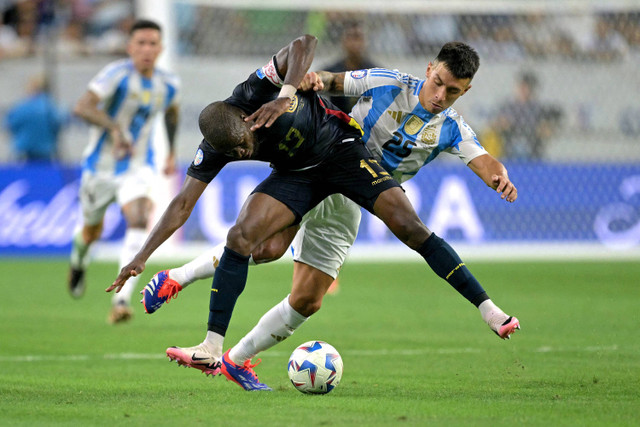 Penyerang Ekuador Enner Valencia berebut bola dengan bek Argentina Lisandro Martinez selama pertandingan sepak bola perempat final turnamen Conmebol 2024 Copa America antara Argentina dan Ekuador di Stadion NRG di Houston, Texas, pada 4 Juli 2024. Foto: JUAN MABROMATA / AFP