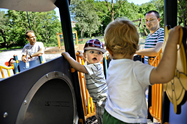 Henrik Holgersson (kanan) melihat putranya, Arvid (tengah bertopi) bermain dengan Walter Johansson yang ditemani ayahnya Henrik Johansson di taman bermain, Stockholm, Swedia, Rabu 29 Juni 2011. Foto: AP Photo/Niklas Larsson