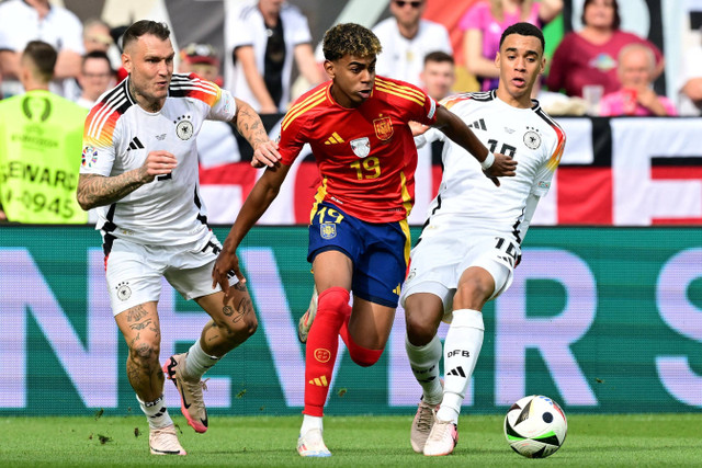 Pemain Timnas Jerman David Raum berebut bola dengan pemain Timnas Spanyol Lamine Yamal pada pertandingan perempat final Piala Eropa 2024 di Stuttgart Arena, Stuttgart, Jerman, Jumat (5/7/2024). Foto: Angelika Warmuth/REUTERS 