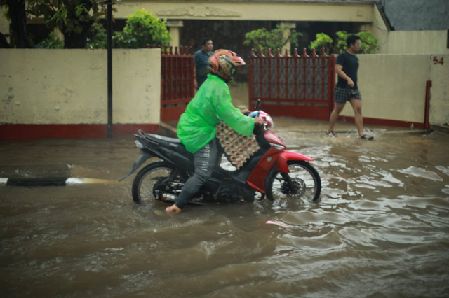 Pengendara melintasi banjir setinggi hingga 40 cm akibat luapan Kali Keungan, Pasanggrahan, Jakarta Selatan, Sabtu (6/7/2024). Foto: Aditia Noviansyah/kumparan