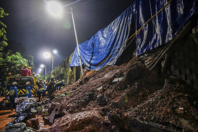 Pekerja membersihkan material longsor tanggul Tol Bintaro, Jakarta, Sabtu (6/7/2024). Foto: Rivan Awal Lingga/ANTARA FOTO