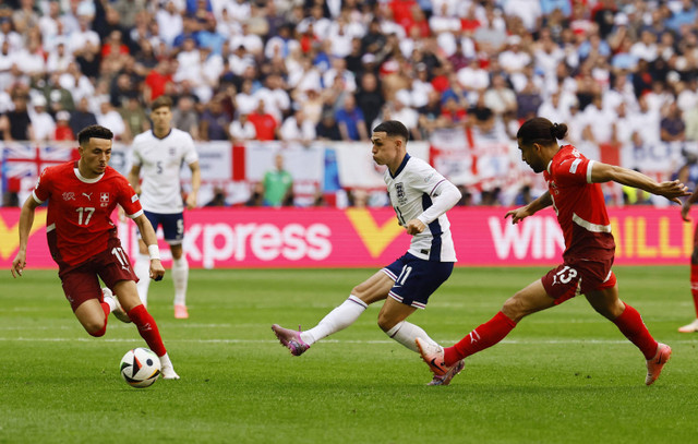 Phil Foden dari Inggris beraksi dengan pemain Swiss Ricardo Rodriguez dan Ruben Vargas saat pertandingan Inggris melawan Swiss pada perempat final Piala Eropa 2024 di Dusseldorf Arena, Jerman, Sabtu (6/7/2024). Foto: Wolfgang Rattay/REUTERS 