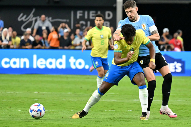 Pemain Timnas Brasil Endrick berebut bola dengan pemain Timnas Uruguay Federico Valverde pada pertandingan perempat final Copa America 2024 di Stadion Allegiant, Las Vegas, Nevada, Amerika Serikat, Sabtu (6/7/2024). Foto: Robyn Beck / AFP