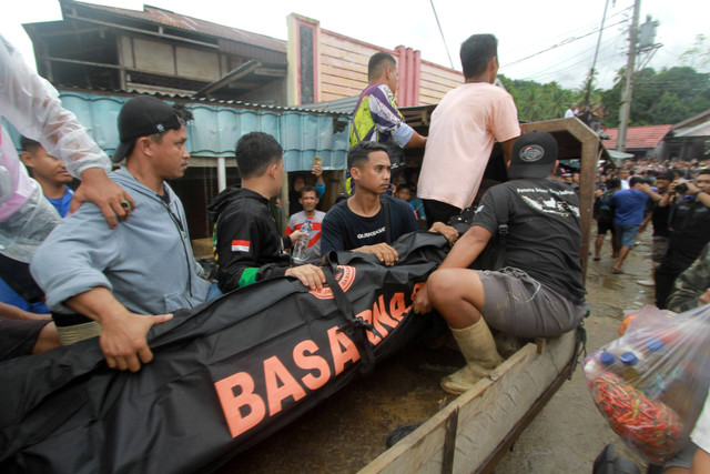 Petugas SAR dan warga mengevakuasi jenazah korban longsor di Desa Tulabolo, Suwawa Timur, Kabupaten Bone Bolango, Gorontalo, Senin (8/7/2024).  Foto: Adiwinata Solihin/ ANTARA FOTO